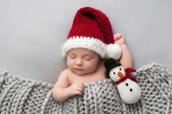 Menino recém-nascido com chapéu de Santa e boneco de neve brinquedo de pelúcia — Fotografia de Stock