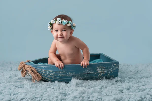 Baby Mädchen sitzt in einem kleinen Boot — Stockfoto