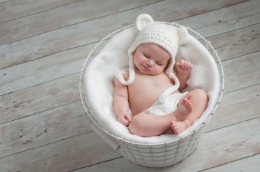 Smiling Baby Wearing a White Bear Hat