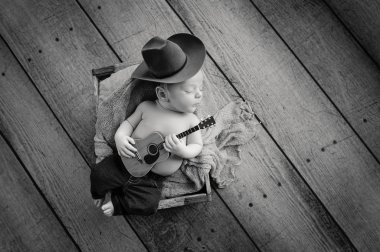 Newborn Baby Cowboy Playing a Tiny Guitar