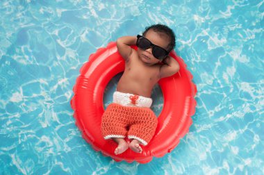 Newborn Baby Boy Floating on a Swim Ring clipart