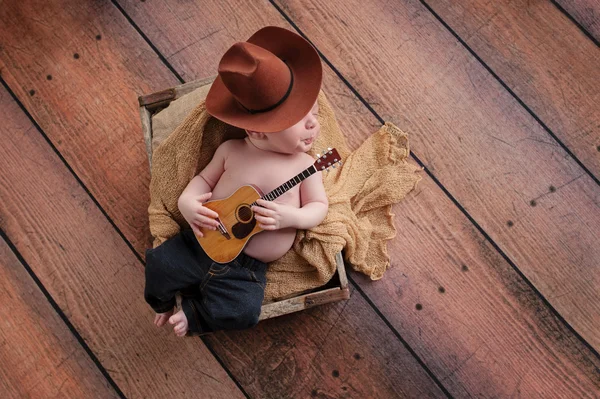 Newborn Baby Cowboy Playing a Tiny Guitar — Zdjęcie stockowe