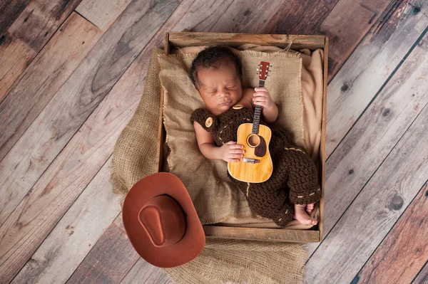 Neugeborener Baby-Cowboy spielt eine winzige Gitarre — Stockfoto