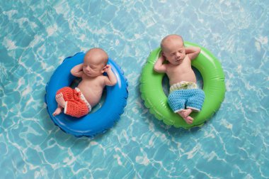 İkiz bebek erkek yüzme halkalar üzerinde yüzen