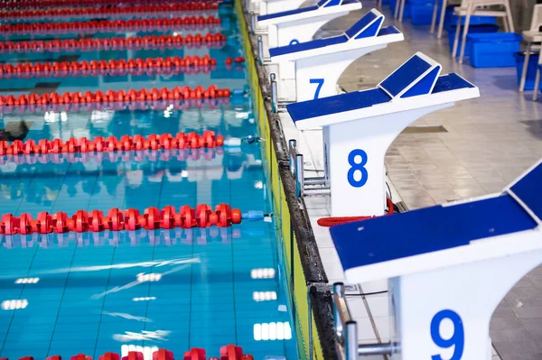 Aligned swimming starting block and platform with numbers — Stock Photo, Image