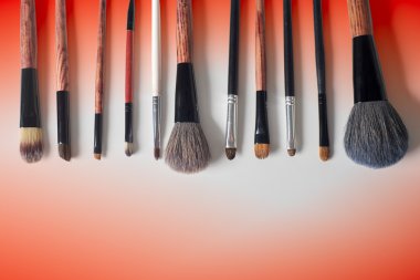 Makyaj fırçası ve kozmetik, renkli arka plan üzerinde