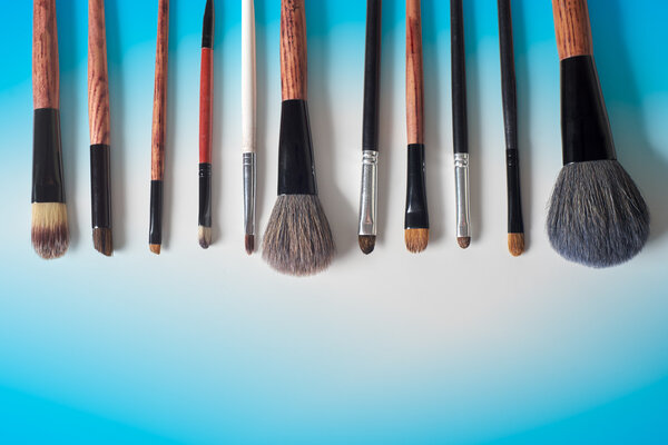 makeup brush and cosmetics, on a color background