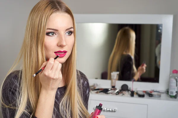 Отклонение молодой красивой женщины, наносящей свой макияж — стоковое фото