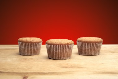 ahşap bir masa üzerinde üç top kek