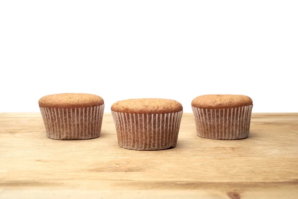 Trois cupcakes sur une table en bois — Photo