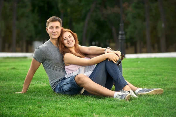 Pareja enamorada sentada en el césped — Foto de Stock