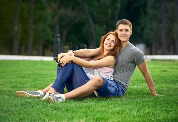 Pareja enamorada sentada en el césped — Foto de Stock