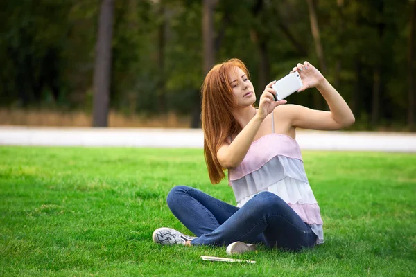 Mulher fotografando-se no parque — Fotografia de Stock