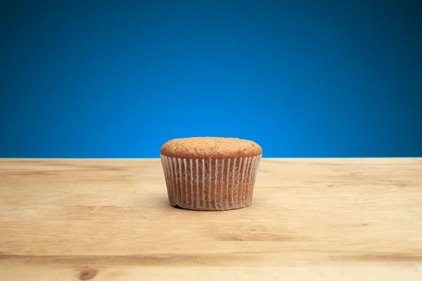 Three cupcakes on a wooden table — Stock Photo, Image