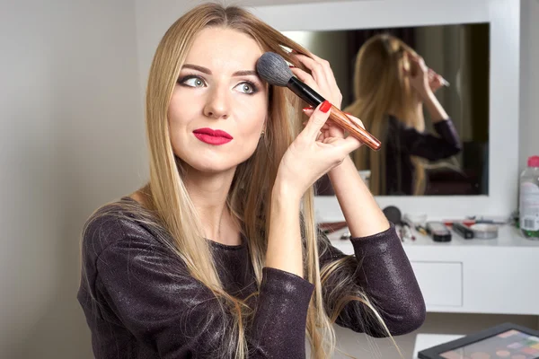 Reflejo de la joven hermosa mujer que aplica su maquillaje — Foto de Stock