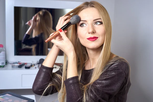 Reflejo de la joven hermosa mujer que aplica su maquillaje — Foto de Stock