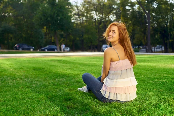 Happy woman with glasses lying on the grass — Stock Photo, Image