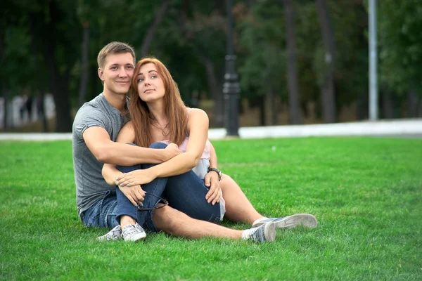 Paar verliefd zittend op het gazon — Stockfoto