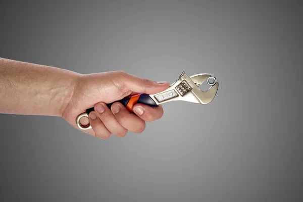 Man's hand holding big wrench