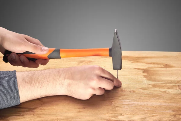 Man hammers a nail with a hammer — Stock Photo, Image