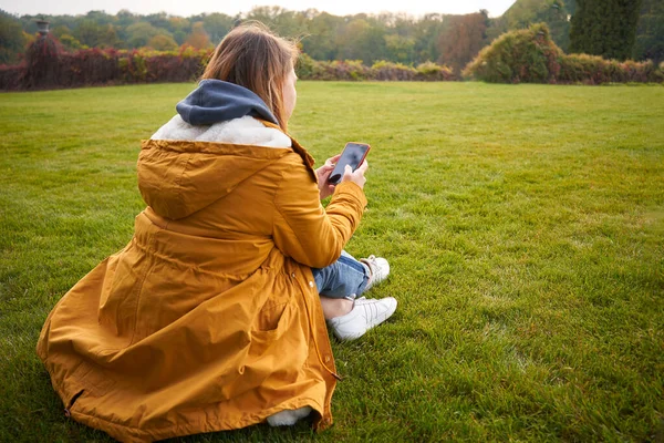 Woman Sits Green Grass Writes Message Smartphone — Stock Photo, Image