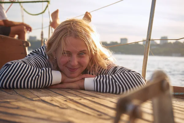 日落时分 在黑海的游艇甲板上躺着一个苦思冥想的微笑的女人 — 图库照片