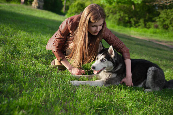 Das Mädchen spielt mit ihrem Hund im Park — Stockfoto