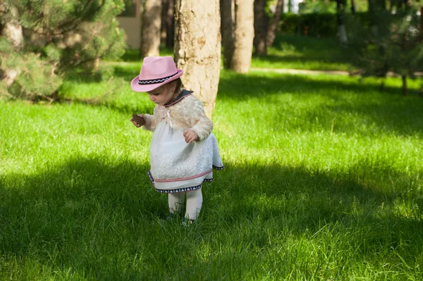 Kleines Mädchen spielt mit Beule auf dem Rasen im Park — Stockfoto