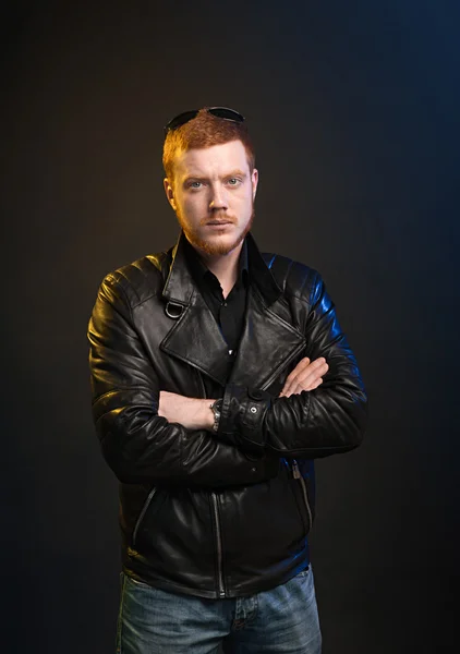Red-haired guy in leather jacket on a dark background — Stock Photo, Image