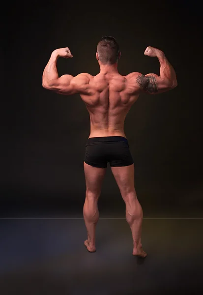 Demonstrates the strong man back muscles — Stock Photo, Image
