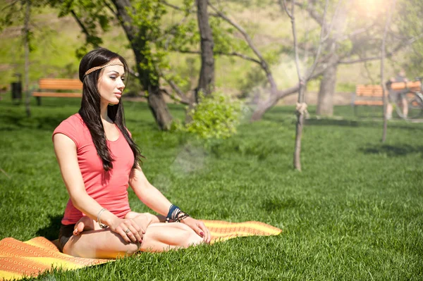 Beautiful woman meditating in the lotus position — Stock Photo, Image