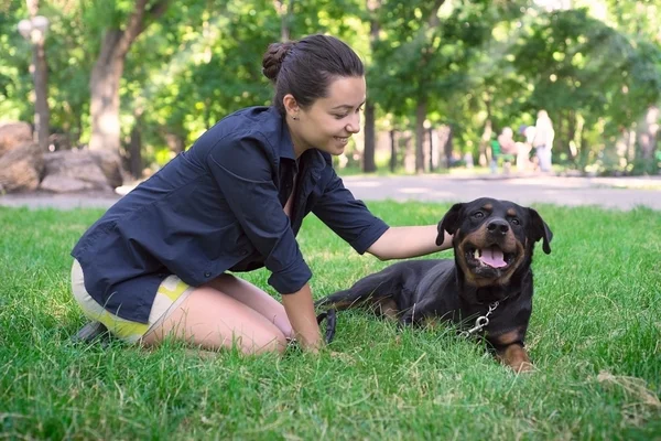 A beautiful woman walks in the park Rottweiler — Stock Photo, Image