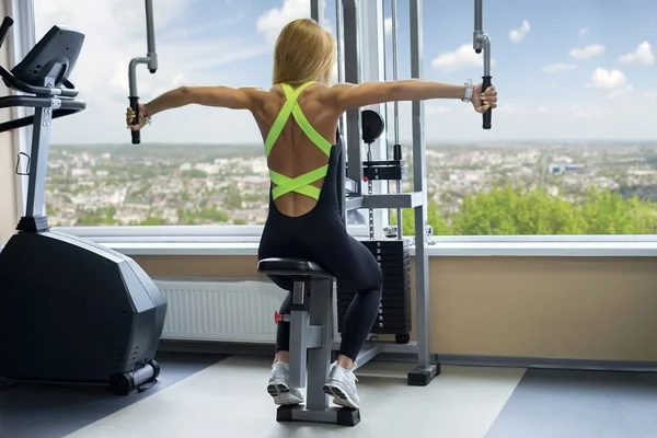 Frau schüttelt im Fitnessstudio die Schultern — Stockfoto