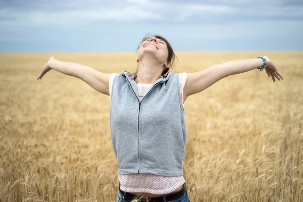 Happy woman in wheat field Stock Picture