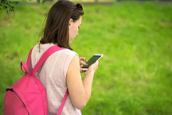 Nő élvezi a telefon, a parkban — Stock Fotó