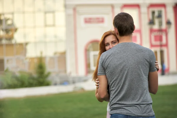 Mujer mira por detrás de un hombre — Foto de Stock