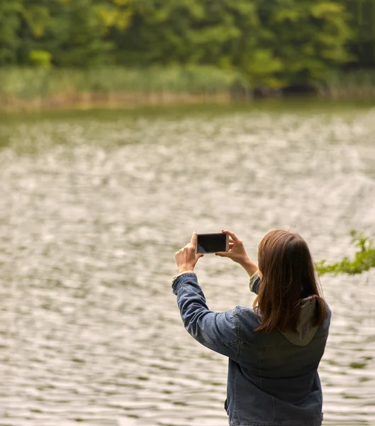 Mujer tomando fotos en la naturaleza del teléfono — Foto de Stock