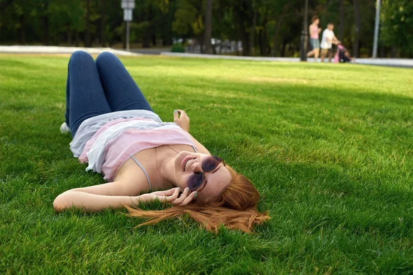 Lächelnde Frau auf dem Rasen liegend — Stockfoto