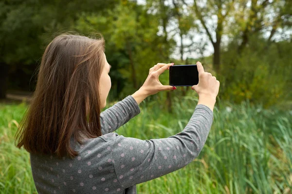 Mujer fotografiando la naturaleza en el bosque — Foto de Stock