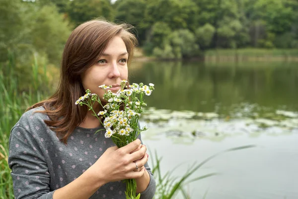 Femme sentant une marguerite — Photo