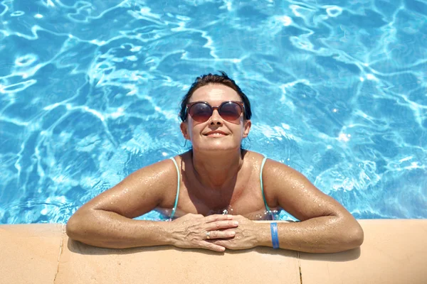 Adult woman relaxing on the swimming pool — Stock Photo, Image