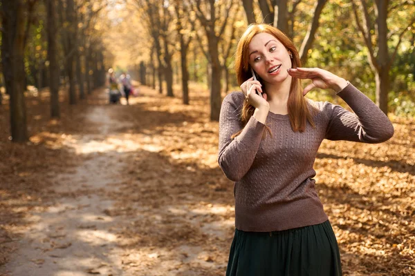 Femme parlant au téléphone dans le parc d'automne — Photo