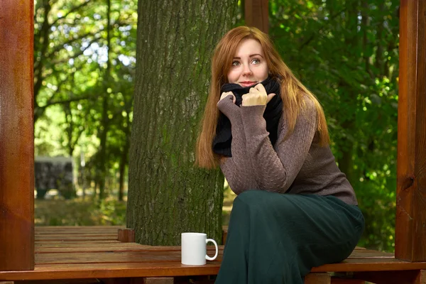 Mujer joven bebiendo café en el parque — Foto de Stock