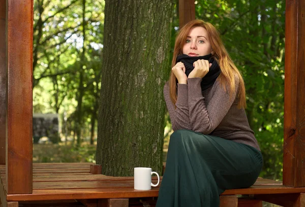 Jeune femme buvant du café dans le parc — Photo