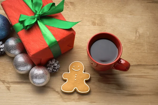 De gift van Kerstmis met een kopje koffie op de tafel — Stockfoto