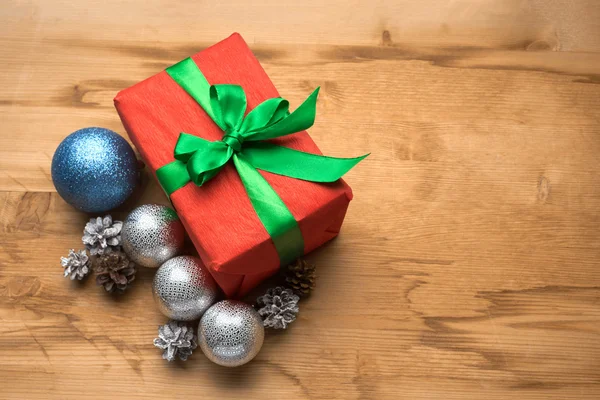 A beautiful red gift with Christmas ornaments — Stock Photo, Image