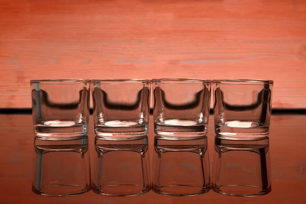 Empty glasses of vodka on a orange background — Stock Photo, Image