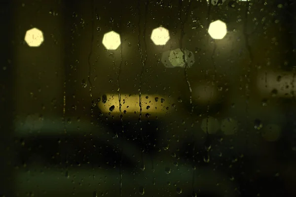 有街灯的窗上的雨滴 — 图库照片