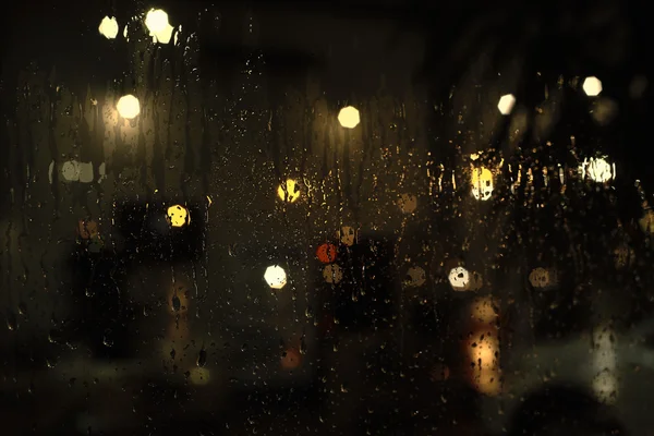 Gotas de lluvia en la ventana con luces bokeh calle — Foto de Stock