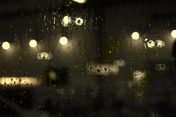 Rain drops on window with street bokeh lights — Stock Photo, Image